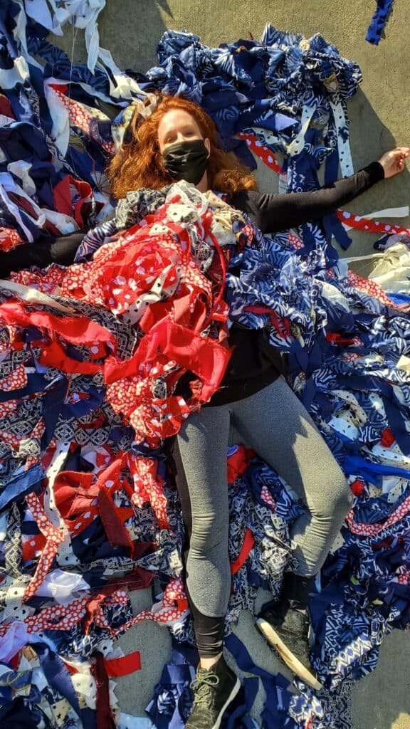Artist Jacqueline von Edelberg surrounded by red, white, and blue fabric. 